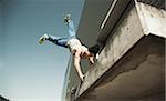 Low angle view of teenaged boy doing handstand on balcony, freerunning, Germany