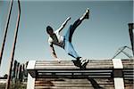 Teenaged boy jumping over barrier, freerunning, Germany