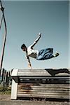 Teenaged boy jumping over barrier, freerunning, Germany