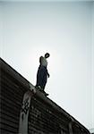 Low angle view of teenaged boy standing on barrier, anticipating next move, Germany