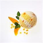 A scoop of apricot and yogurt ice cream, apricot wedges and lemon balm