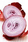 A red onion, halved, with skin