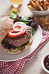 A home-made hamburger with cucumber, tomato and lettuce