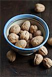 Walnuts in a bowl on a wooden surface