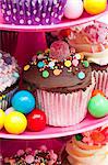 Colorful cupcakes and candies for a party on a cake stand