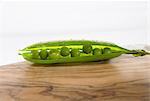 Open pea pod on a wooden board