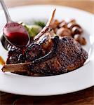 Spooning a Glaze Over Frenched Lamb Chops; In a White Bowl