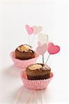 Miniature chocolate cakes topped with heart-shaped decorations