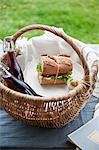 A picnic basket with a sandwich and drinks