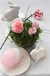 An idea for an Easter decoration: a porcelain hare, and paper pinks in a nest made of moss
