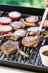 Lamb chops being brushed with marinade on the barbecue