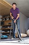 Man cleaning house with a vacuum cleaner