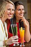 Two female friends enjoying drinks in a restaurant