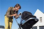 Man showing mobile phone to a baby in stroller