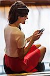Woman text messaging on a mobile phone and smiling