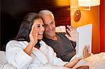 Couple video calling on a digital tablet in a hotel room