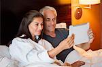 Couple watching movie on a digital tablet in a hotel room