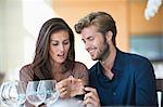 Man giving engagement ring to his girlfriend in a restaurant