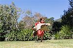 Girl playing with a cardboard airplane in lawn