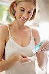 Woman pouring moisturizer on a cotton