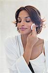 Woman cleaning her face with a cotton pad