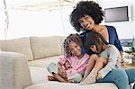 Smiling woman sitting with her two daughters