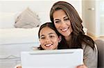 Woman and her daughter looking at a digital tablet