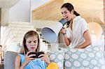 Woman shouting through a megaphone at his daughter for playing video game