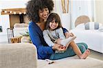 Woman putting on socks to her daughter and smiling