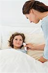 Woman checking fever of her son with a thermometer