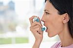 Close-up of a woman using an asthma inhaler