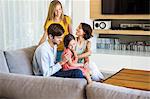 Parents with their children sitting in a living room