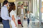 Man with his daughter arriving at his friends home from holiday