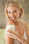 Beautiful smiling woman cleaning with a bath sponge