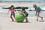 Woman playing with her grandchildren on the beach