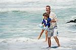 Boy playing with his grandfather on the beach