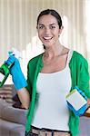 Portrait of a woman holding cleaning equipment and smiling