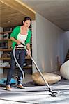 Woman cleaning house with a vacuum cleaner