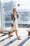 Woman talking on a mobile phone while walking on an airport