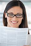 Close-up of a woman reading a document and smiling