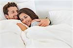 Smiling couple lying on the bed