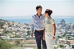 Couple looking at each other on a terrace with city in the background