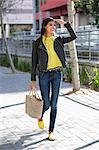 Woman walking on a street and shielding her eyes