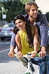 Couple riding a bicycle and smiling