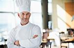 Portrait of a chef smiling with arms crossed in a restaurant