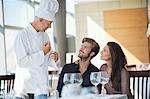 Chef talking to couple at restaurant