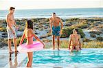 Group of friends enjoying in a swimming pool on the beach