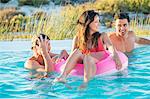 Three friends enjoying in a swimming pool on the beach