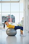 Woman exercising on a fitness ball in a gym