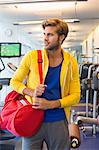 Man carrying a bag in a gym